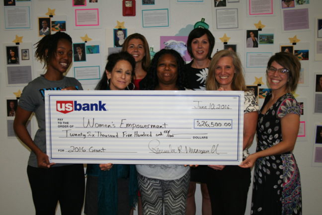 Women's Empowerment staff and graduates hold a check from U.S. Bank for $26,500.