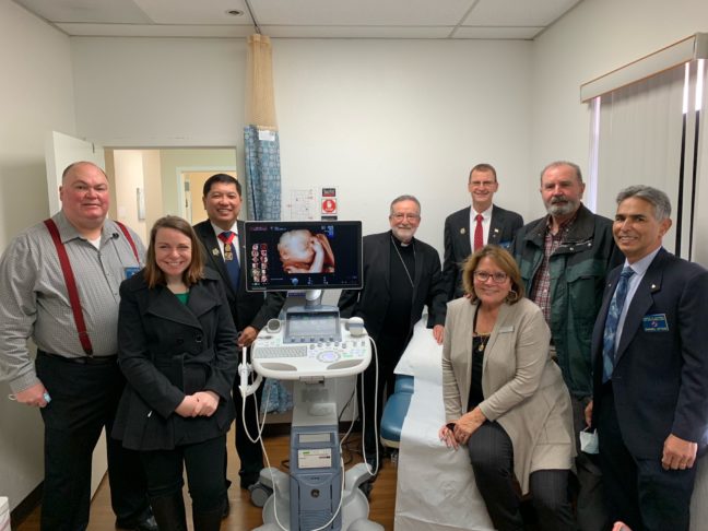 Members of the Knights of Columbus Fair Oaks Council gather around the ultrasound machine they donated to the Sacramento Life Center along with the pregnancy center's staff