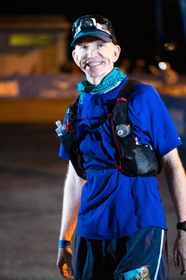 Dr. Phelan wears a blue shirt and running gear in the early morning before sunrise