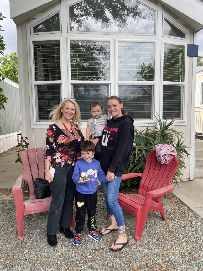 Women’s Empowerment Executive Director Lisa Culp meets with a program graduate at her home in the nonprofit’s Trellis Gardens transitional workforce housing program