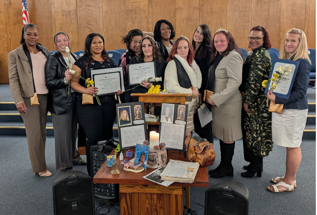 Graduates of Women's Empowerment stand together with their certificates in December